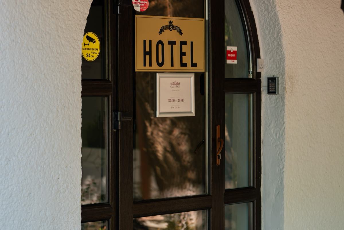 Ușa de la intrarea în hotel, cu firma pe perete