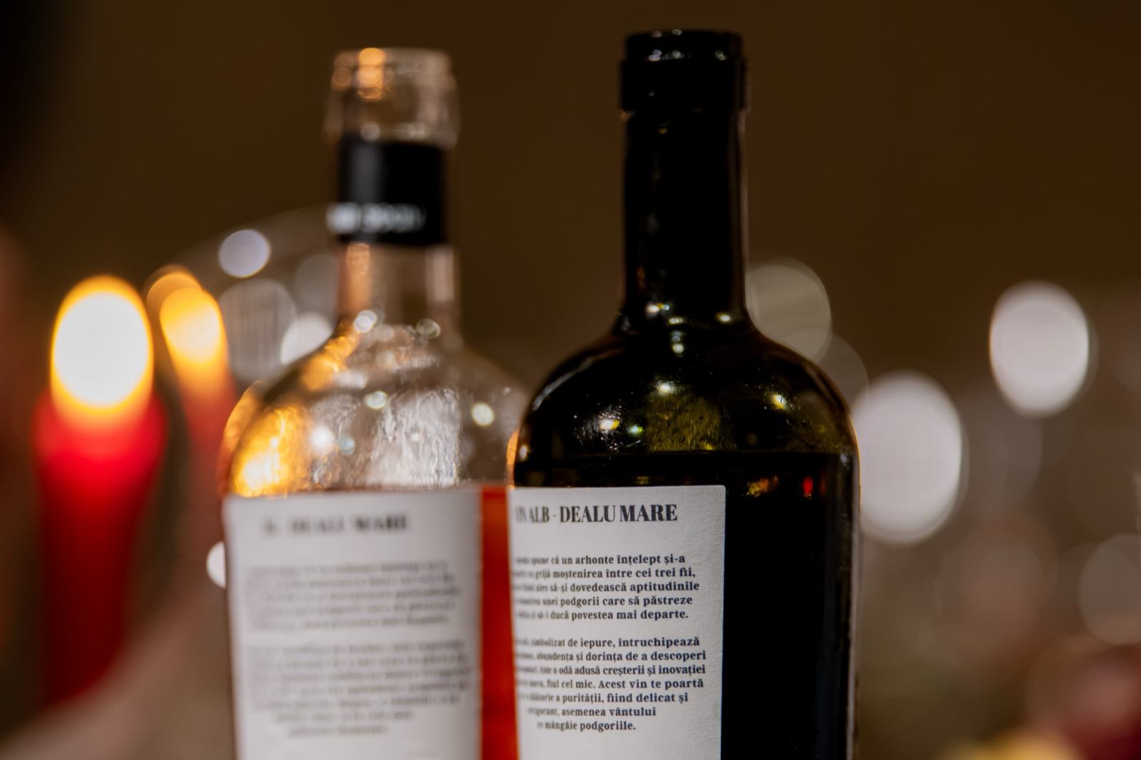 Două sticle de vin Casa Seciu pe masă, în lumina lumânărilor