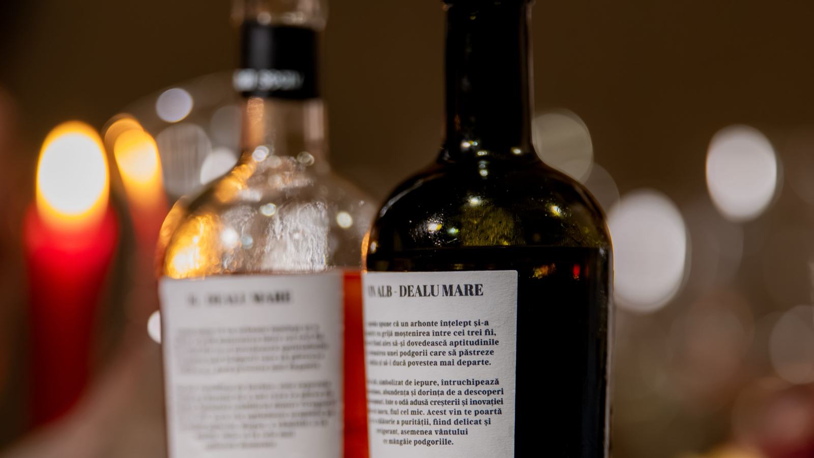 Două sticle de vin Casa Seciu pe masă, în lumina lumânărilor